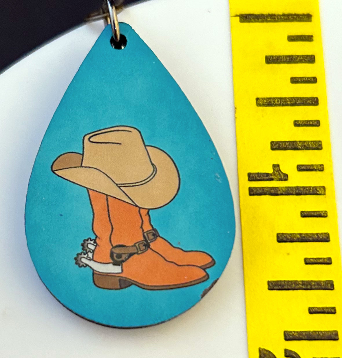teardrop earrings with cowboy boots and hat on blue background